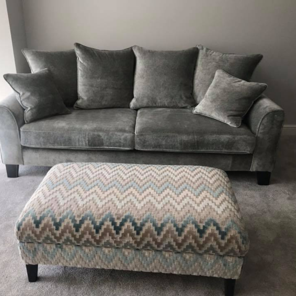 grey sofa with cushions and zigzag patterned footstool